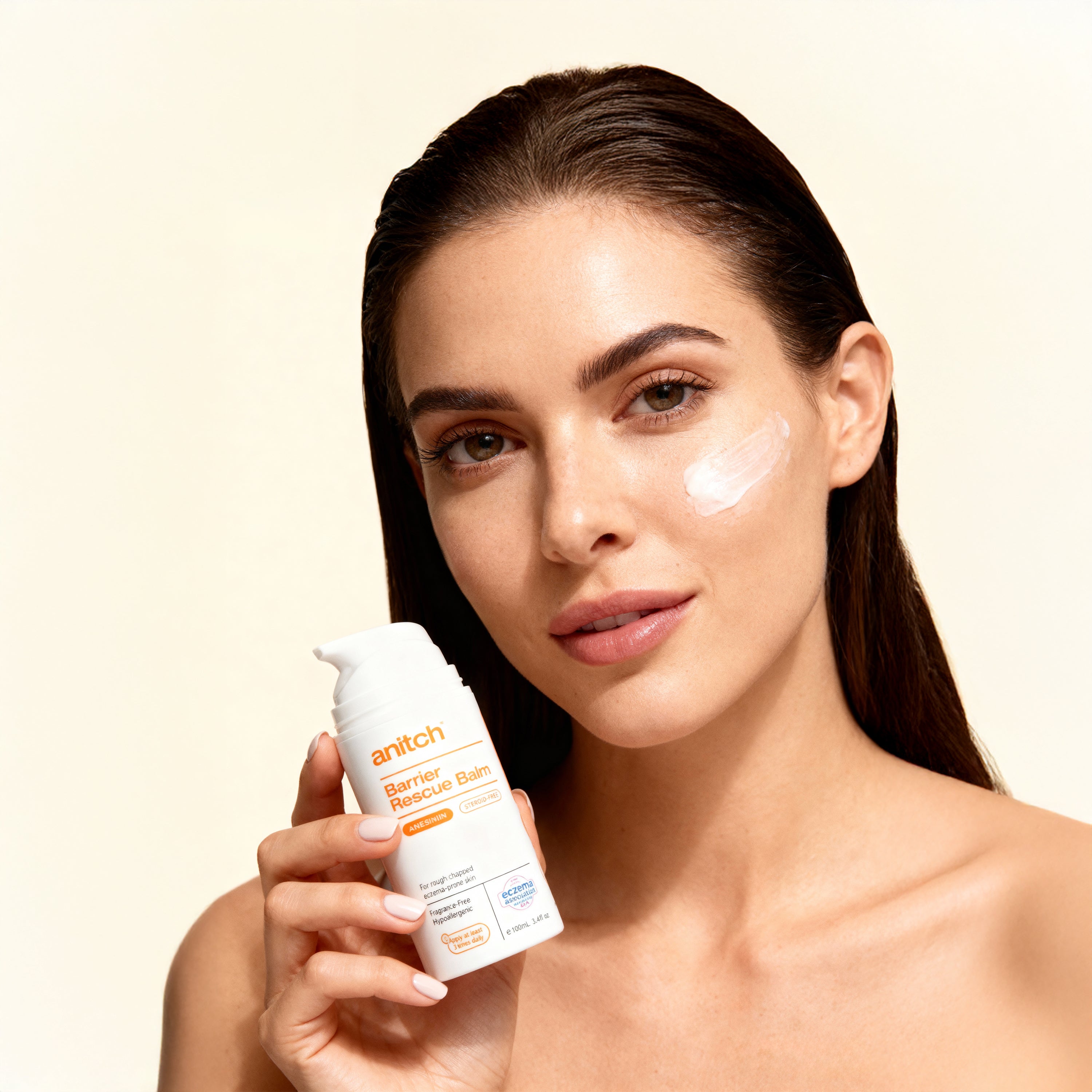 Woman holding a skincare product with a beige background