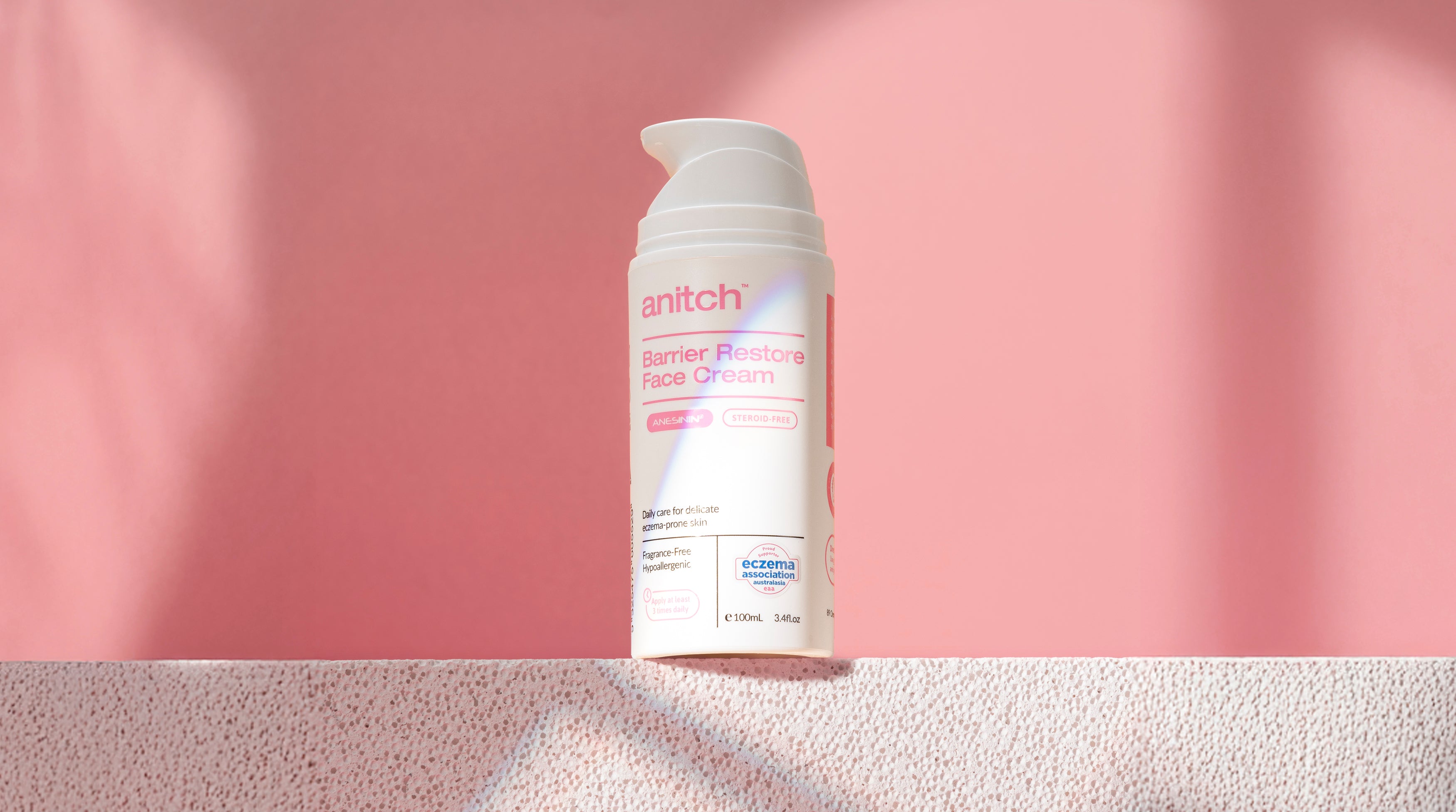 Skincare cream bottle labeled 'Anitch' on a pink background