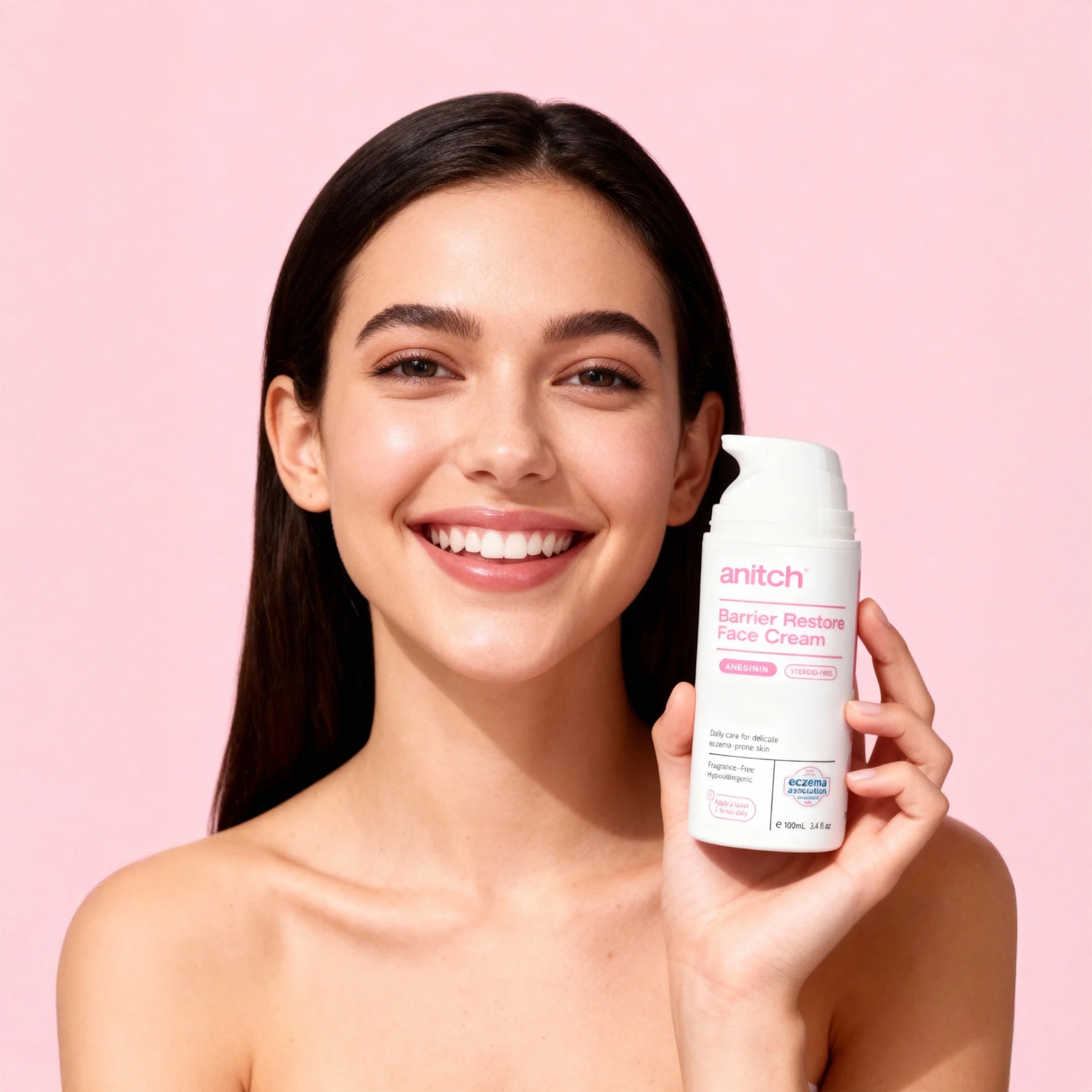 Woman holding a skincare product against a pink background