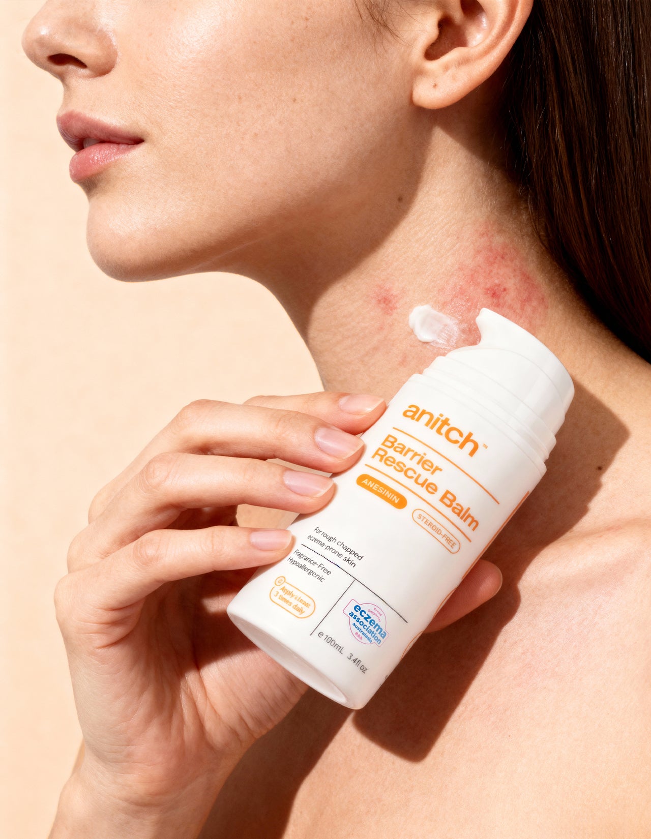 Person applying anitch balm to their neck with a beige background